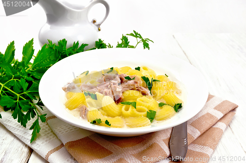 Image of Soup creamy of chicken and pasta in plate on towel