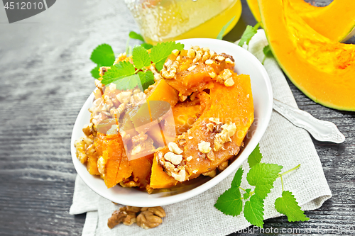 Image of Pumpkin with nuts and honey on dark wooden board