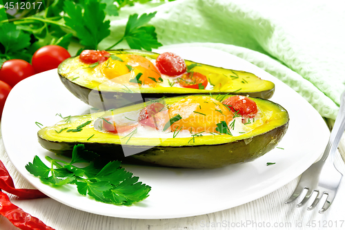 Image of Scrambled eggs with tomatoes in avocado on board