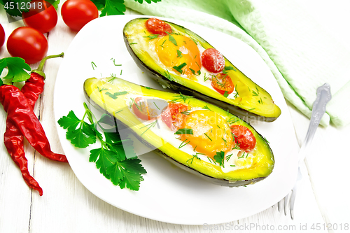 Image of Scrambled eggs with tomatoes in avocado on white board