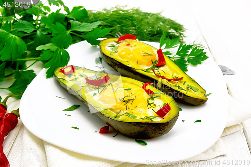 Image of Scrambled eggs with peppers in avocado on white board