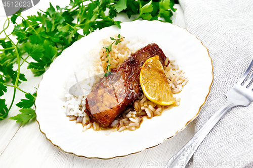 Image of Salmon with sauce and rice in plate on light board