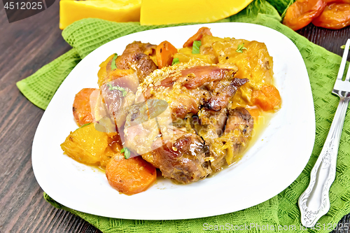 Image of Chicken roast with pumpkin and dried apricots on dark board