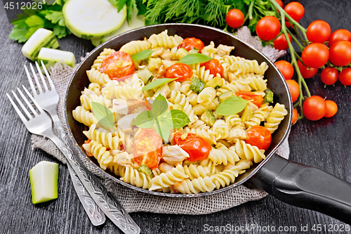 Image of Fusilli with chicken and tomatoes in pan on board