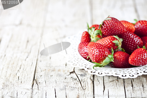 Image of Organic red strawberries on white plate on rustic wooden backgro