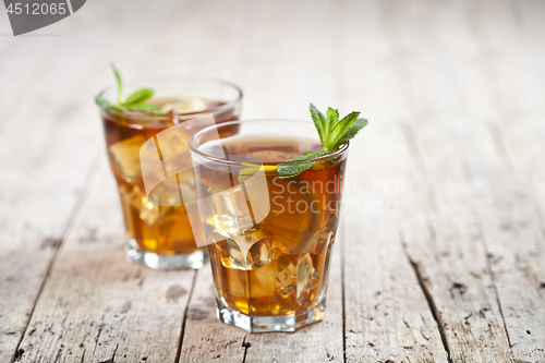 Image of Two glasses with traditional iced tea with lemon, mint leaves an