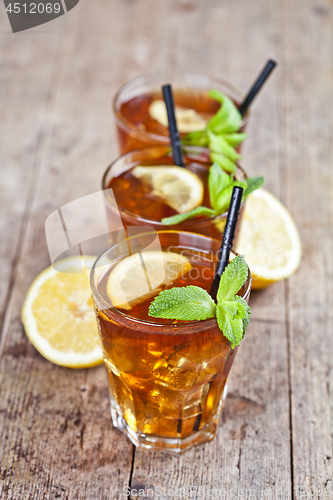 Image of Traditional iced tea with lemon, mint leaves and ice cubes in th