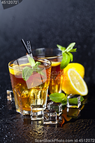 Image of Two glasses with cold traditional iced tea with lemon, mint leav