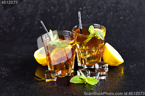 Image of Two glasses with cold traditional iced tea with lemon, mint leav