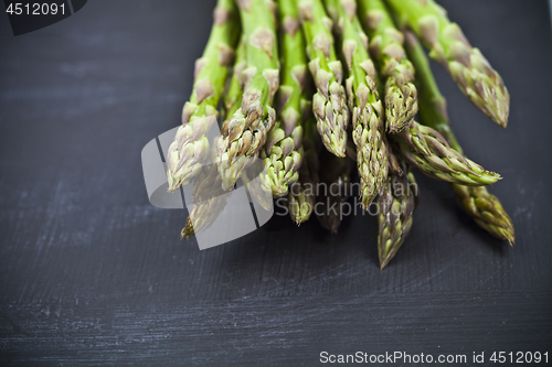 Image of Bunch of fresh raw garden asparagus closeup on black board backg