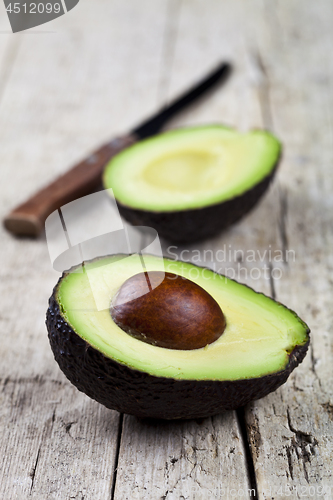 Image of Avocado and knife on old wooden table background. Fresh avocado 