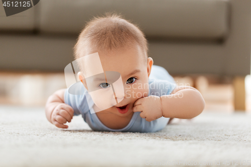 Image of sweet little asian baby boy lying on floor at home