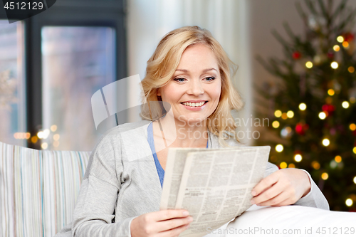 Image of woman reading newspaper on christmas at home