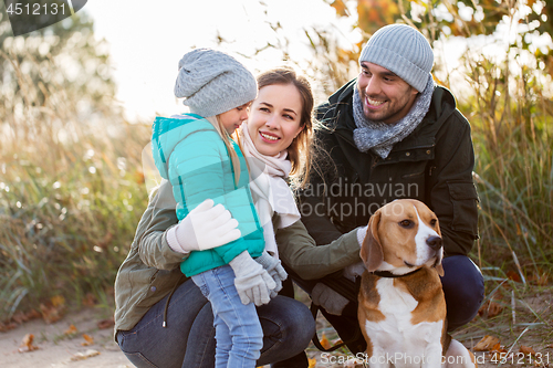 Image of happy family with beagle dog outdoors in autumn