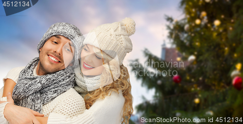 Image of happy couple hugging over christmas tree