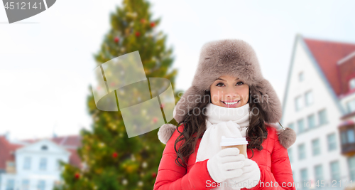 Image of woman with coffee over christmas tree in tallinn