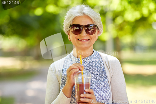 Image of senior woman drinking takeaway shake at park