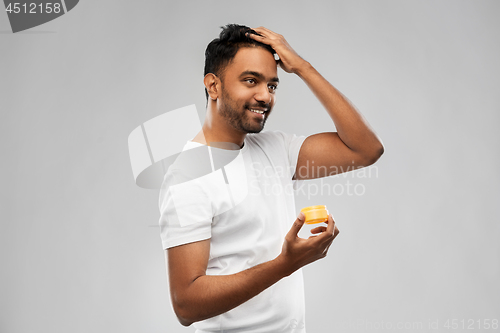 Image of indian man applying hair wax or styling gel