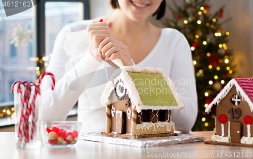 Image of woman making gingerbread houses on christmas