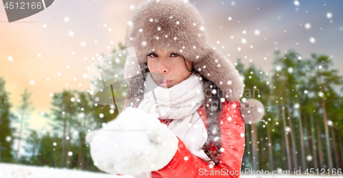 Image of woman in fur hat with snow over winter forest