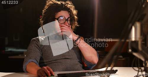 Image of man working on computer in dark office