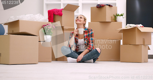 Image of woman with many cardboard boxes sitting on floor