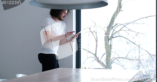 Image of young man using a tablet at home