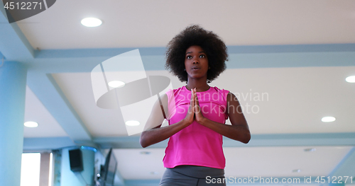 Image of back woman in a gym stretching and warming up