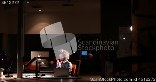 Image of man working on computer in dark office