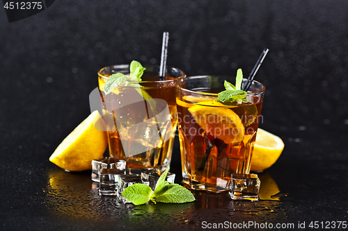 Image of Two glasses with cold traditional iced tea with lemon, mint leav