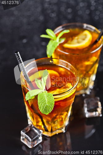 Image of Two glasses with cold traditional iced tea with lemon, mint leav