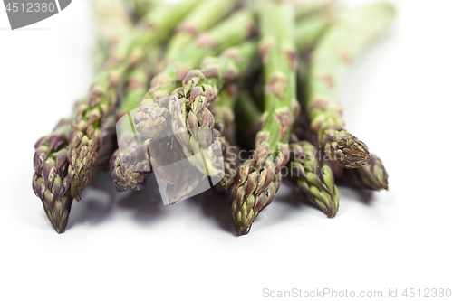 Image of Bunch of fresh raw garden asparagus closeup on white background.