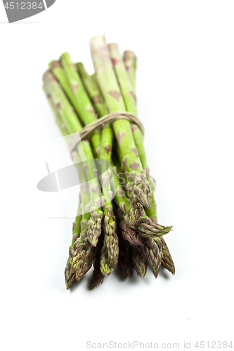 Image of Bunch of fresh raw garden asparagus closeup on white background.