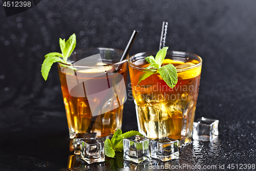 Image of Two glasses with cold traditional iced tea with lemon, mint leav