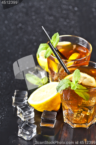 Image of Two glasses with cold traditional iced tea with lemon, mint leav