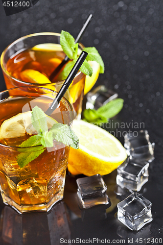 Image of Two glasses with cold traditional iced tea with lemon, mint leav