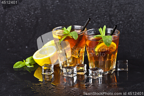 Image of Two glasses with cold traditional iced tea with lemon, mint leav