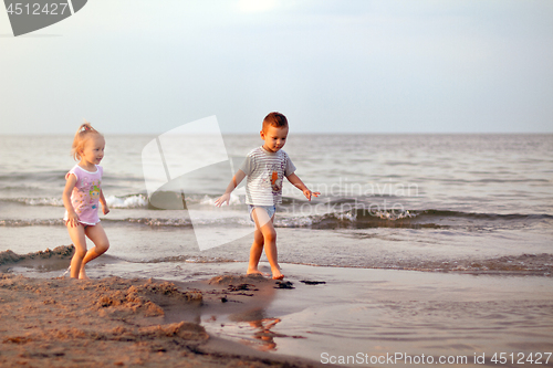 Image of Happy family brother and sister playing on the beach