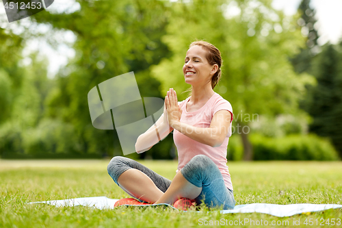 Image of happy woman meditating in summer park