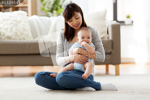 Image of happy young mother with little baby at home