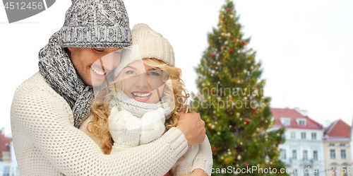 Image of happy couple hugging over christmas tree