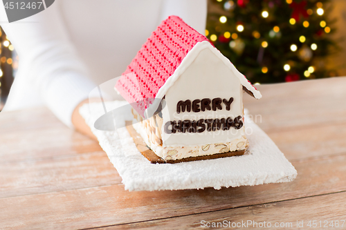 Image of close up of woman with christmas gingerbread house