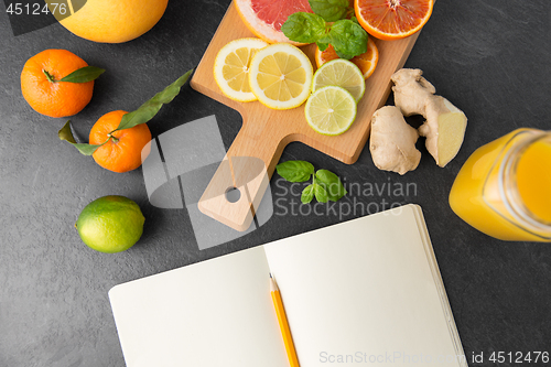 Image of close up of fruits and notebook on slate table top