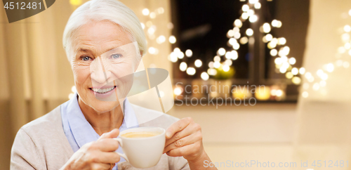 Image of happy senior woman with cup of coffee on christmas