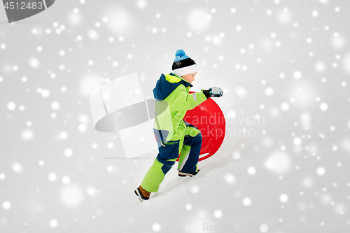 Image of happy boy with snow saucer sled in winter