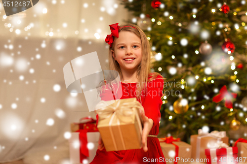 Image of smiling girl with christmas gift at home