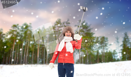 Image of happy woman taking selfie over winter forest