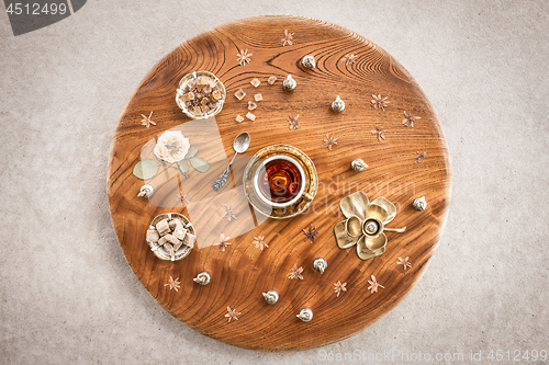 Image of Round wooden table with tea and flowers