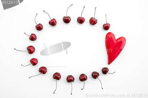 Image of Frame made of cherries and red wooden heart