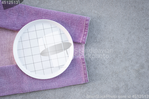 Image of Checked white plate and lilac tablecloth